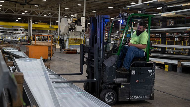 Forklift in plant lifting grain bin roof panels